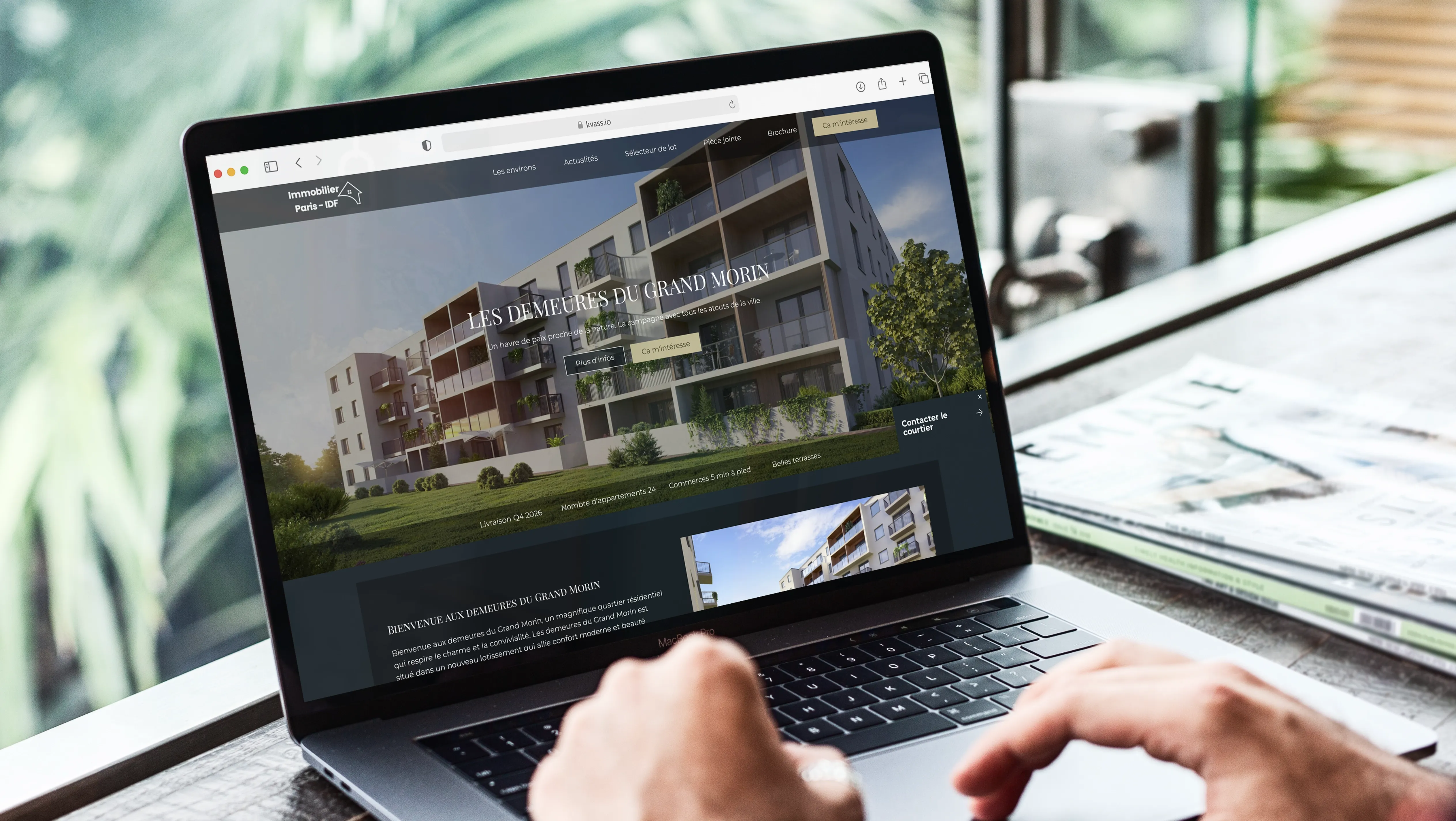Une personne utilise un ordinateur portable affichant la page web d’un projet immobilier nommé « Les Demeures du Grand Morin » sur la plateforme Kvass, montrant une visualisation 3D d’un immeuble résidentiel moderne et des informations clés du programme.